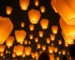 Globos de Cantoya iluminando el cielo nocturno en una celebración.