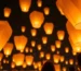 Globos de Cantoya iluminando el cielo nocturno en una celebración.