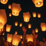 Grupo de personas lanzando globos de Cantoya al cielo nocturno.