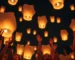 Grupo de personas lanzando globos de Cantoya al cielo nocturno.