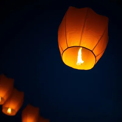 Primer plano de un globo de Cantoya iluminado en el cielo.