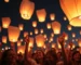 Globos de Cantoya iluminando el cielo nocturno en un evento festivo.