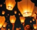 Personas lanzando globos de Cantoya en un evento nocturno