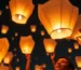 Personas lanzando globos de Cantoya en un evento nocturno
