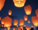 Globos de Cantoya iluminando el cielo nocturno en un evento corporativo.