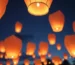 Globos de Cantoya iluminando el cielo nocturno en un evento corporativo.